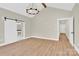 Bright bedroom showcases a modern light fixture, wood floors, and doorways to the bathroom and hall at 124 Starboard Ln, Statesville, NC 28677