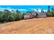 Side view of a new home with white siding, dark trim and a sloped lot at 124 Starboard Ln, Statesville, NC 28677