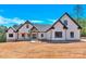 New construction home boasts a white exterior with dark trim, set against a bright blue sky at 124 Starboard Ln, Statesville, NC 28677