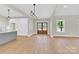Open-concept living area featuring hardwood floors, light fixtures, and a double-door entryway at 124 Starboard Ln, Statesville, NC 28677