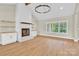 Bright living room features a fireplace, white wood-paneled wall, wooden shelves, and modern light fixture at 124 Starboard Ln, Statesville, NC 28677