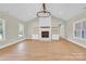 Bright living room features a fireplace, white wood-paneled wall, wooden shelves, and modern light fixture at 124 Starboard Ln, Statesville, NC 28677