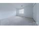 This bedroom features neutral carpet, a window, and a closet at 12749 Mosby Ln, Charlotte, NC 28273