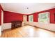 Cozy living room with red wallpaper, hardwood floors, and a vintage piano at 1285 10Th Street Nw Blvd, Hickory, NC 28601