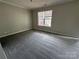 A bedroom features neutral walls, plush carpeting, and a window with natural light at 1300 Braveheart Ln, Charlotte, NC 28216