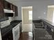 A kitchen area features dark cabinets, laminate countertops, and modern appliances at 1300 Braveheart Ln, Charlotte, NC 28216