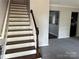 An entryway view of a staircase and carpeted living room in a modern home at 1300 Braveheart Ln, Charlotte, NC 28216
