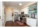 Modern kitchen with stainless steel appliances, white cabinets, and glass display shelving at 1320 Fillmore Ave # 426, Charlotte, NC 28203