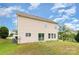 Back of home featuring tan siding, multiple windows, and a sliding glass door to the grassy yard at 13816 Riding Hill Ave, Charlotte, NC 28213
