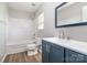 Bathroom with tub-shower combo, gray cabinets, and modern fixtures at 13816 Riding Hill Ave, Charlotte, NC 28213