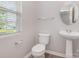 Cozy bathroom with wood-look vinyl flooring, pedestal sink, and a bright window view at 13816 Riding Hill Ave, Charlotte, NC 28213