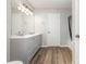 Modern bathroom with double sink vanity, wood-look flooring, and contemporary lighting fixture at 13816 Riding Hill Ave, Charlotte, NC 28213