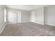 A bright bedroom with neutral walls and carpet, featuring two entry doors and a ceiling fan at 13816 Riding Hill Ave, Charlotte, NC 28213