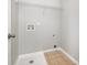 Compact laundry room with hookups, overhead rack and light brown floor tiles at 13816 Riding Hill Ave, Charlotte, NC 28213