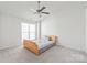 Bright bedroom with a ceiling fan, large window, neutral carpet, and a minimalist wooden bed frame at 1707 Kashmir White Ln, Fort Mill, SC 29708