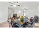 Open dining area featuring a ceiling fan, dark wood table, and a comfortable leather couch at 1707 Kashmir White Ln, Fort Mill, SC 29708