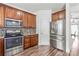 Well-lit kitchen features stainless steel appliances and warm wood cabinetry with stylish backsplash at 1707 Kashmir White Ln, Fort Mill, SC 29708