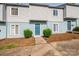 Charming townhome featuring a painted facade, complemented by lush green bushes, and individual front entrances at 1905 Mereview Ct # 21, Charlotte, NC 28210
