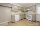 A galley kitchen with white appliances and grey cabinets, offering a functional and modern cooking space at 1905 Mereview Ct # 21, Charlotte, NC 28210