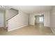 A spacious living room, featuring neutral walls, tiled floors, and an open staircase, transitions into another room at 1905 Mereview Ct # 21, Charlotte, NC 28210