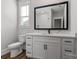 This primary bathroom features a white cabinet, marble-look countertops, and a large, framed mirror at 1933 Hendricks St, Rock Hill, SC 29732
