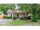 Charming single-story home with light yellow siding, quaint front porch, and mature landscaping at 2212 Acme Rd, Belmont, NC 28012