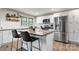 Modern kitchen with stainless steel appliances, a kitchen island with bar stool seating, and bright lighting at 2212 Acme Rd, Belmont, NC 28012