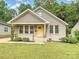 Charming bungalow-style house featuring a yellow front door and a well-manicured lawn at 2323 Arden St, Charlotte, NC 28206
