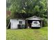View of backyard garages on a grassy lot with a parked silver car at 247 E Cabarrus Ave, Concord, NC 28025