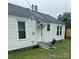 View of the back of this white home, including the door, yard, and roof at 247 E Cabarrus Ave, Concord, NC 28025