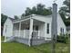 Quaint home showcasing a covered front porch, white siding, and well-maintained landscaping at 247 E Cabarrus Ave, Concord, NC 28025