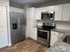 Modern kitchen with white cabinets, granite counters, and stainless steel appliances at 247 E Cabarrus Ave, Concord, NC 28025
