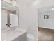 Modern bathroom with gray vanity, sleek mirror, and doorway to bedroom at 2608 Croydon Rd, Charlotte, NC 28209