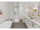 Bright bathroom featuring a soaking tub, glass shower, double vanity, and gold fixtures at 2608 Croydon Rd, Charlotte, NC 28209
