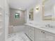 Bathroom featuring a shower-tub combo, double vanity, and natural light at 2608 Croydon Rd, Charlotte, NC 28209
