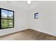 Bedroom with hardwood floors and natural light from two windows showing verdant landscaping at 2608 Croydon Rd, Charlotte, NC 28209