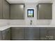 Stylish kitchenette featuring grey cabinets, quartz countertops, sleek fixtures and stainless steel faucet at 2608 Croydon Rd, Charlotte, NC 28209
