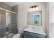 Bathroom featuring a glass shower, neutral gray tile, blue vanity, white countertop, toilet, and a well-lit mirror at 2863 Grand Union Way, Charlotte, NC 28209