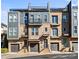 Modern brick townhomes featuring a rooftop terrace, balconies, individual garages, and manicured landscaping at 2863 Grand Union Way, Charlotte, NC 28209
