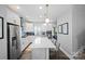 Bright kitchen featuring stainless steel appliances, white cabinetry, a center island with seating, and modern fixtures at 2863 Grand Union Way, Charlotte, NC 28209