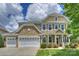 Charming two-story home boasts stone accents, a three-car garage, and lush landscaping at 3029 Allendale Dr, Fort Mill, SC 29707