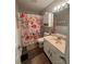 Well-lit bathroom with a floral shower curtain, neutral vanity, and a toilet at 303 Heritage Pkwy, Fort Mill, SC 29715