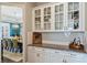 Butler's pantry featuring granite countertops, glass-front cabinets, and view into the dining room at 305 Decanting Ln, Fort Mill, SC 29707