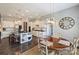 Modern white kitchen with stainless appliances, island, and adjacent breakfast nook with a round table at 305 Decanting Ln, Fort Mill, SC 29707