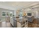 Kitchen island with granite countertop, white cabinets, and view to breakfast and living areas at 305 Decanting Ln, Fort Mill, SC 29707