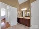 Bathroom featuring a dark wood vanity, a large mirror, and neutral colored tile floors at 3610 Providence Mill Rd, Maiden, NC 28650