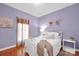 A cozy bedroom with light purple walls, hardwood floors, and a white metal bed frame at 3610 Providence Mill Rd, Maiden, NC 28650