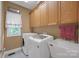 Well-lit laundry room featuring washer, dryer, sink, and overhead cabinets at 3610 Providence Mill Rd, Maiden, NC 28650