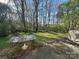 A serene backyard featuring a glass table, lush trees, and greenery, perfect for outdoor relaxation at 3898 Longwood Sw Dr, Concord, NC 28027