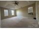 Spacious bedroom with neutral carpet, ceiling fan, and multiple windows offering natural light at 3898 Longwood Sw Dr, Concord, NC 28027